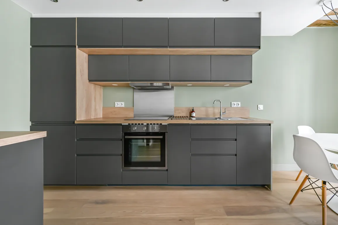 Modern luxury kitchen: charcoal grey, light wood. Sleek, functional design.