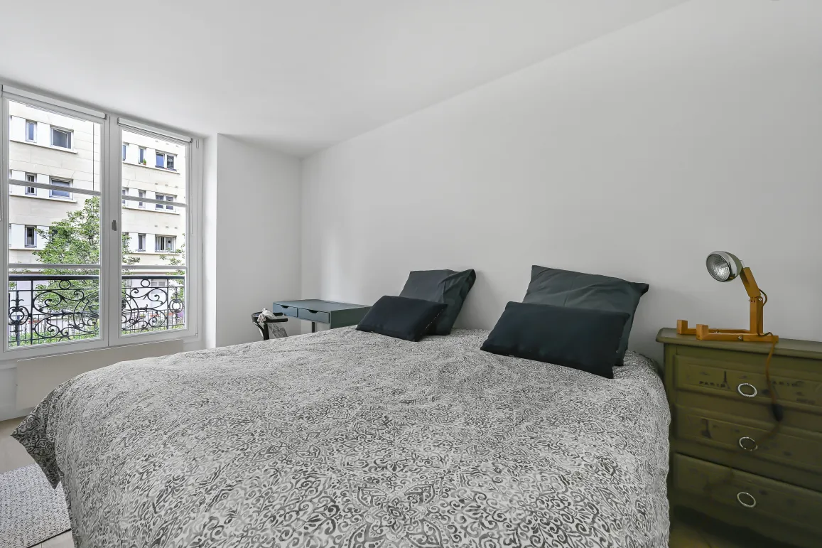 Luminous master bedroom, sleek design, urban view, wrought iron balcony. Comfort and elegance for your luxury apartment.