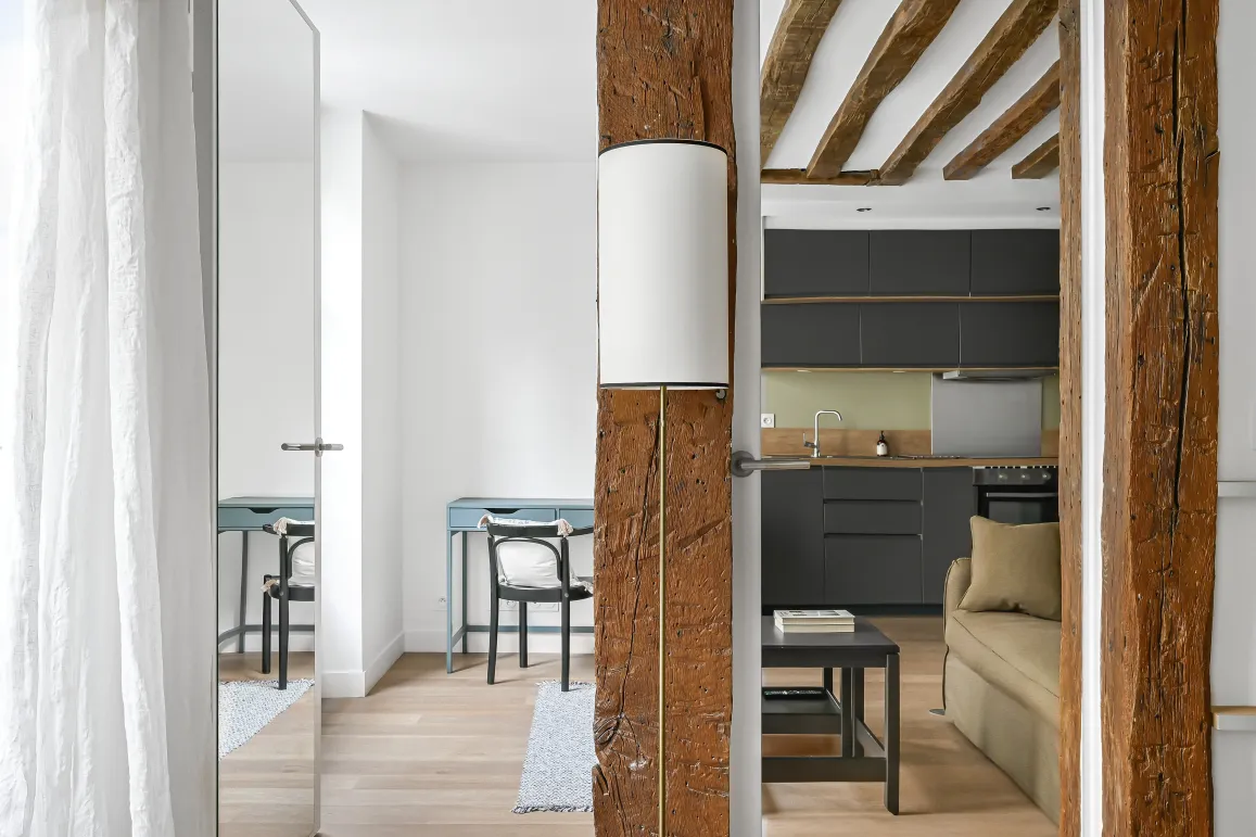 Luxury renovated interior: exposed beams, modern kitchen, elegant design. Old charm meets contemporary comfort.