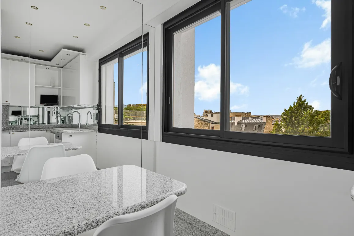 Bright modern kitchen, granite island, urban view. Sleek design for a contemporary luxury apartment.