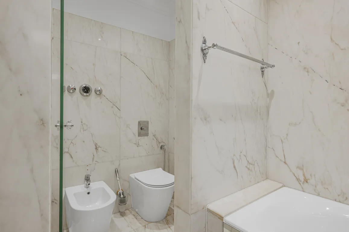 Luxury marble bathroom with shower, bathtub, toilet, and bidet. Elegant design and high-end finishes.