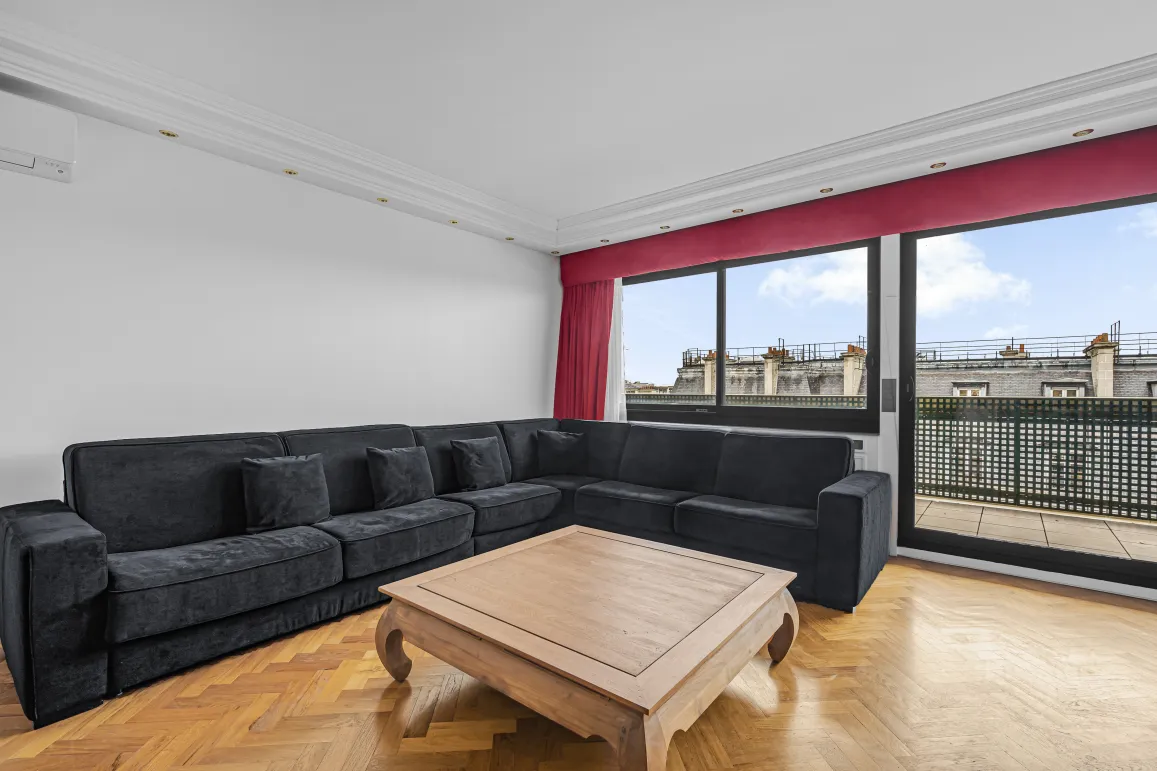 Bright, modern luxury living room. Large sofa, hardwood floor, Paris rooftop view and balcony.