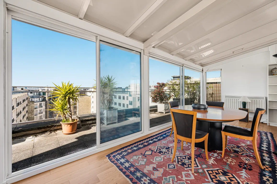 Bright dining room with panoramic city views and terrace access. An elegant and sunny urban living space.