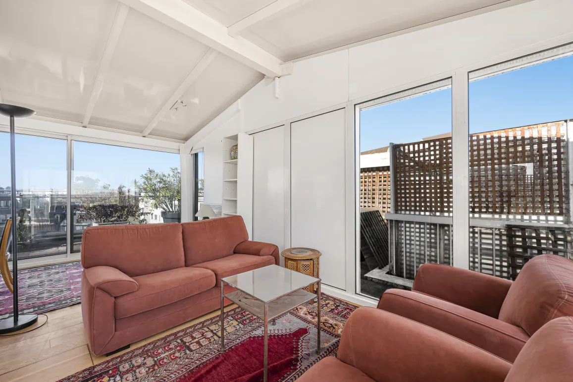 Bright penthouse living room with terrace view, large bay windows. Luxury apartment, modern comfortable space. Ideal urban living.