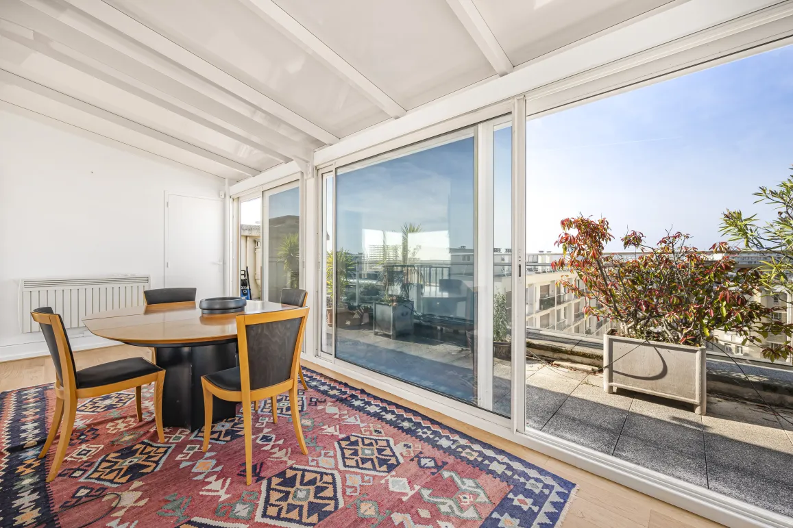 Bright solarium/veranda dining area with direct access to a private rooftop terrace offering open city views. Perfect for a luxury penthouse.