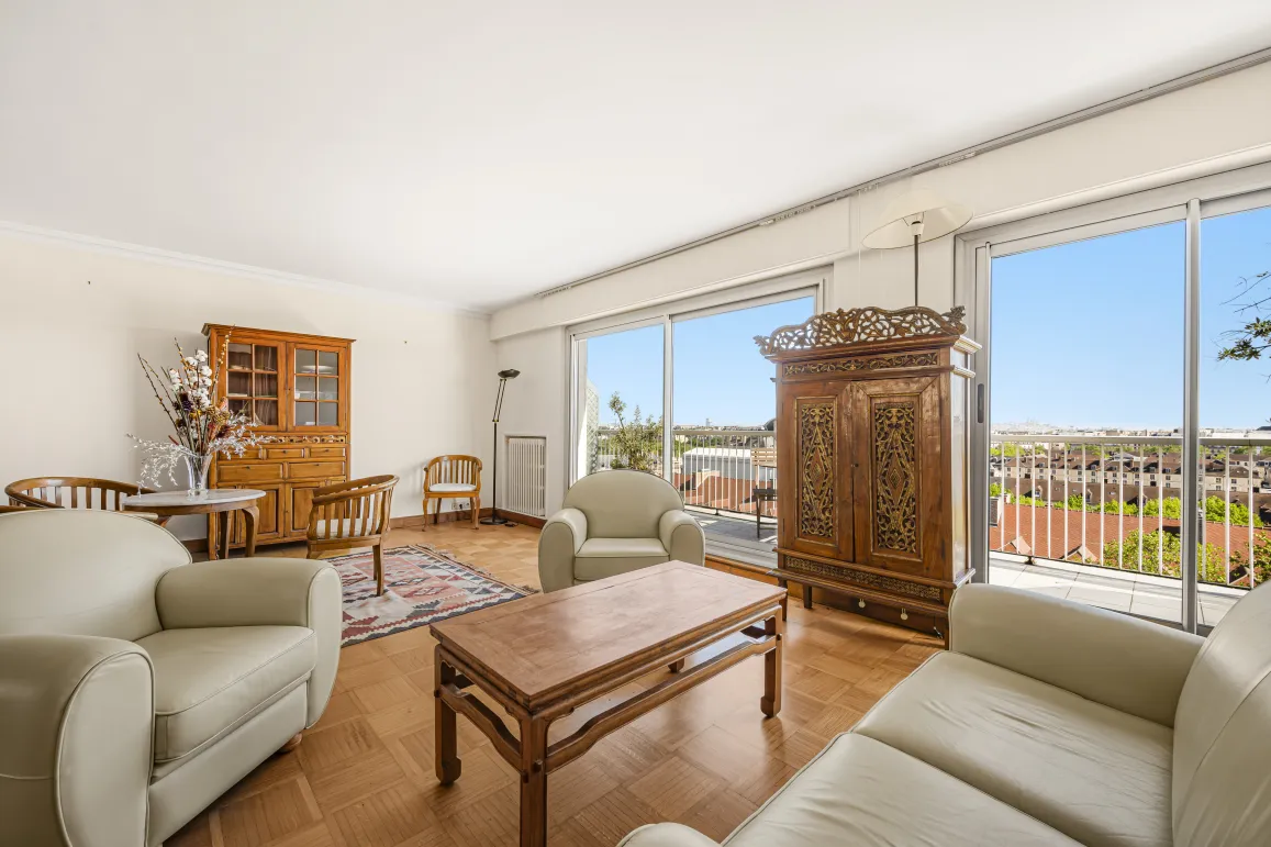 Bright living room with panoramic city view, hardwood floors, and refined furniture. Luxury apartment with terrace.