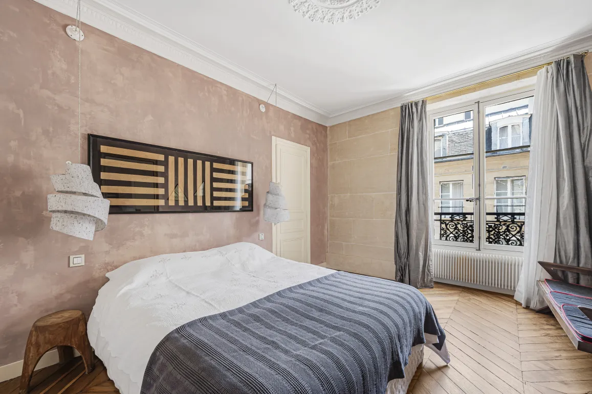 Luxury Parisian bedroom. Modern design, textured walls, parquet flooring, city view. Elegant and refined ambiance.