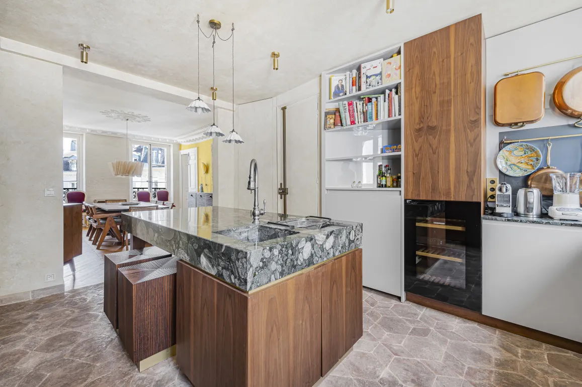 Luxury kitchen with marble and wood island, modern and elegant design. Open space to dining room. Haussmannian apartment.