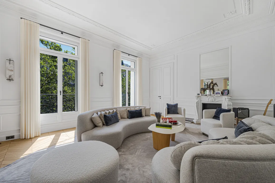 Modern luxury living room, bright. Curved designer sofas, Parisian elegance, green views.