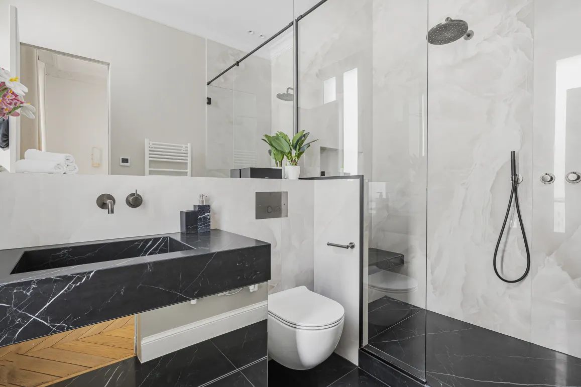 Luxury black and white marble bathroom. Walk-in shower, designer vanity. Contemporary elegance for high-end property.