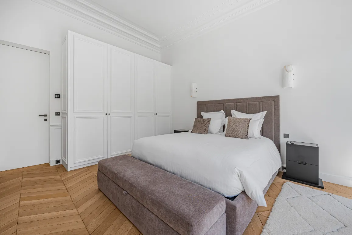 Contemporary luxury bedroom, minimalist design. Comfortable bed, built-in closet, hardwood floor. Bright and elegant ambiance.