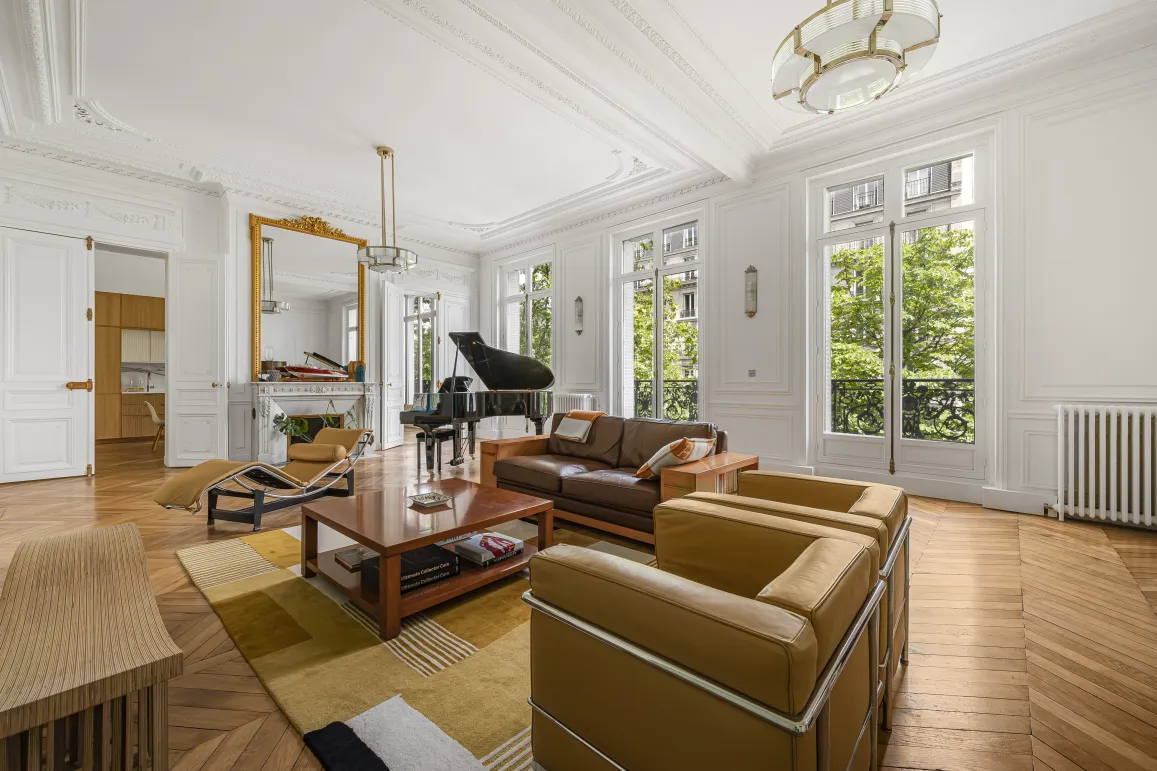 Luxury Parisian Haussmannian living room: grand piano, parquet, mouldings, fireplace, green view. Elegant & bright.