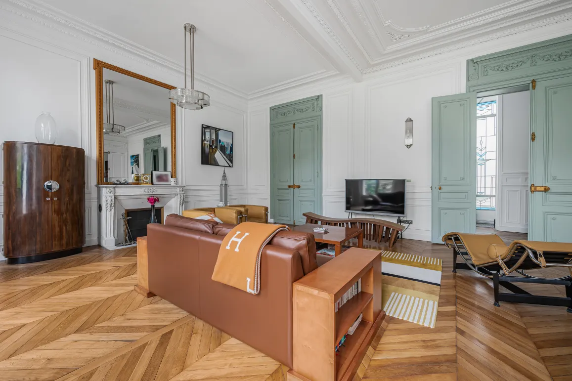 Luxurious Haussmannian apartment, bright living room with chevron parquet, moldings, fireplace & Art Deco design furniture.