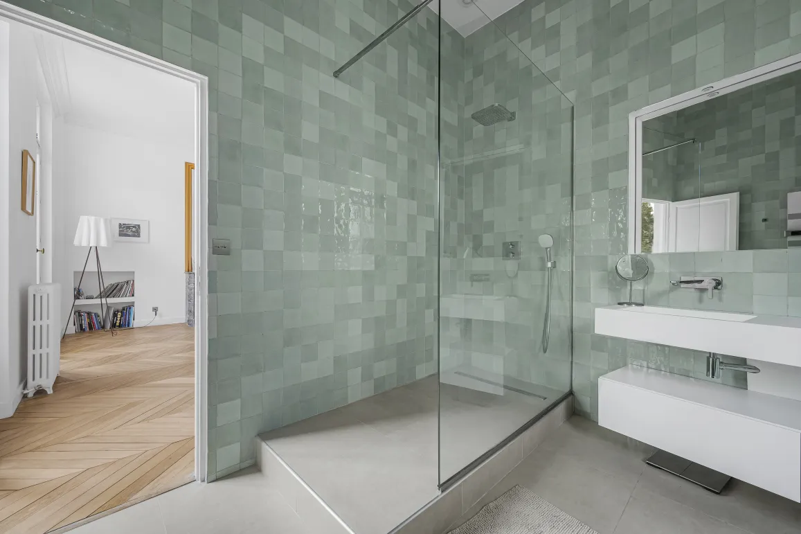 Modern luxury bathroom with walk-in shower and elegant mint green zellige tiles. High-end design for a sophisticated apartment.