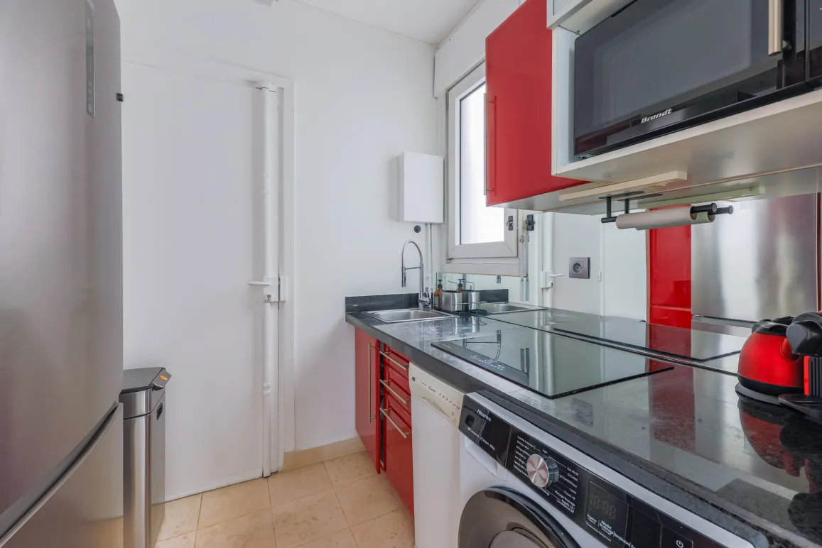 Modern, elegant, fully equipped kitchen (washer, microwave), contemporary red and black design. Ideal for luxury apartment.