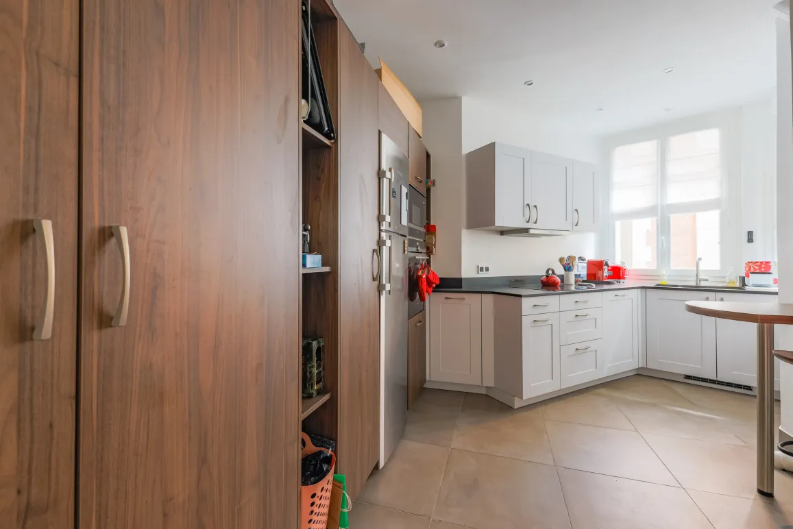 Bright, modern kitchen with elegant wood cabinetry, integrated stainless steel appliances, and high-end finishes. Perfect for luxury real estate.