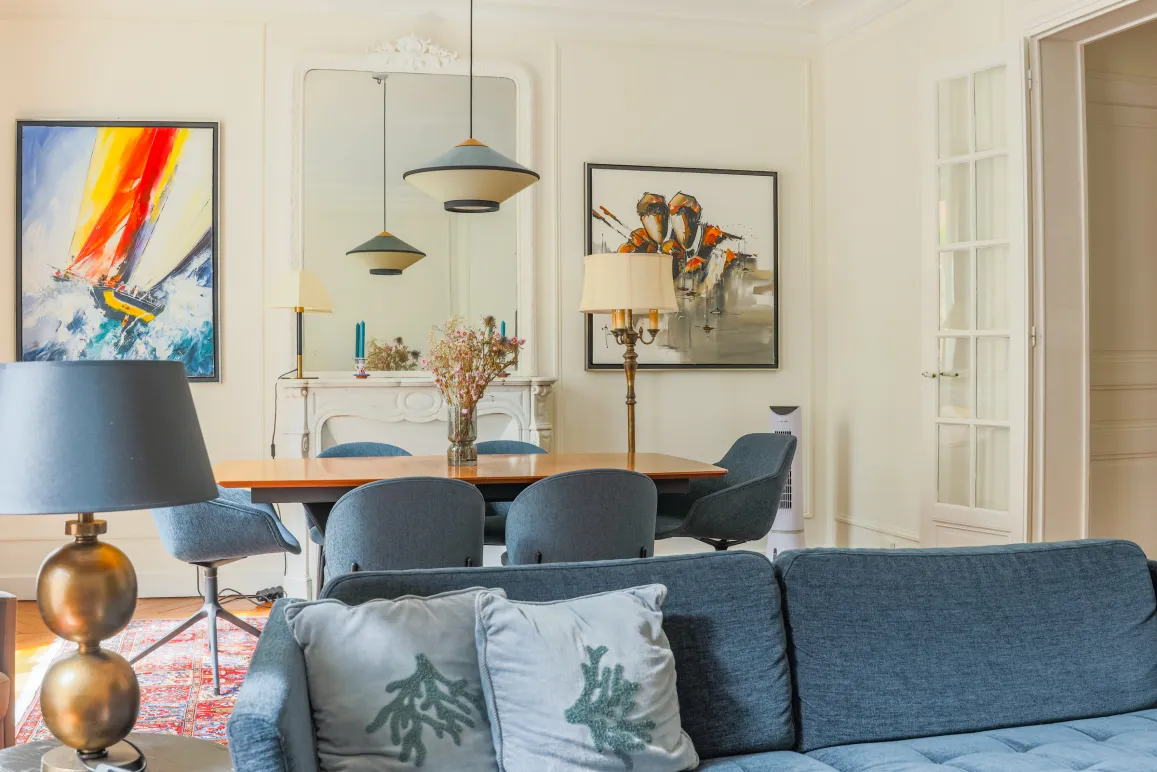 Elegant living-dining room in a luxury apartment. Contemporary design, refined furniture, artworks. Bright and chic ambiance.