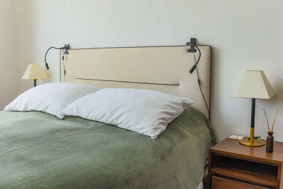 Modern luxury bedroom. Cozy bed, designer headboard, integrated lighting, elegant bedside table. Serene space for optimal rest.