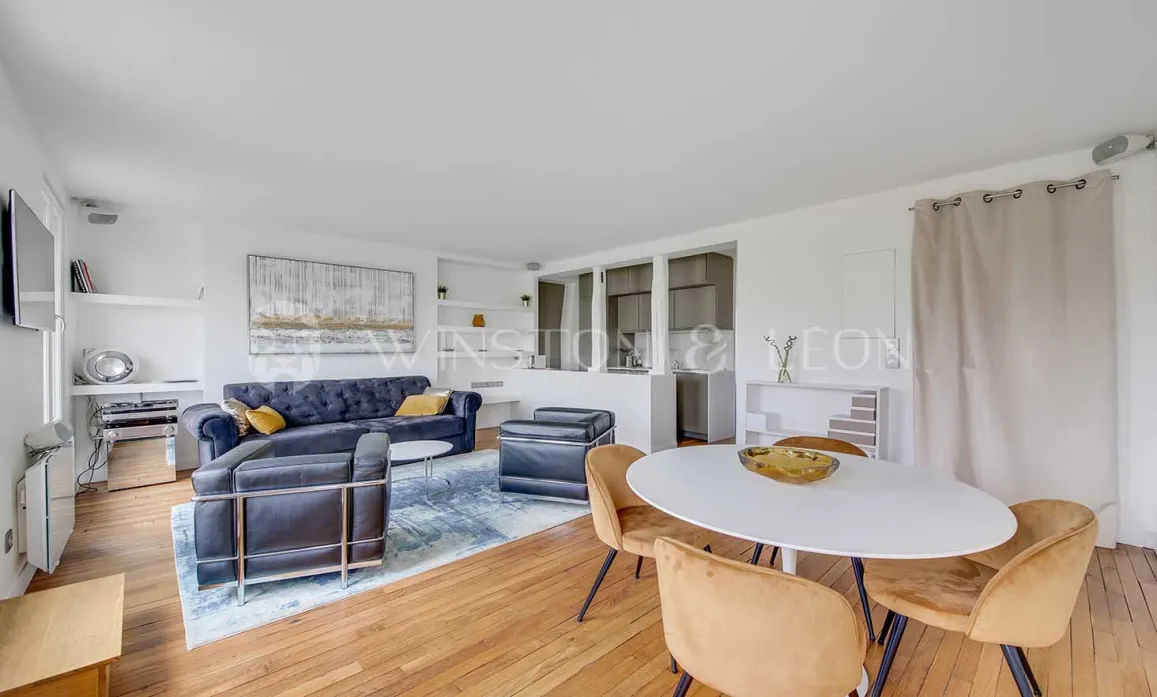 Bright modern living & dining room. Velvet sofa, design armchairs, oval table. Chic contemporary interior for luxury property.