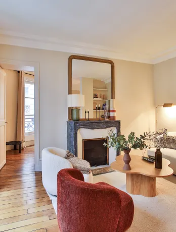 Luxury Parisian living room, modern and elegant design with fireplace, hardwood floor, natural light. Ideal for a high-end apartment.